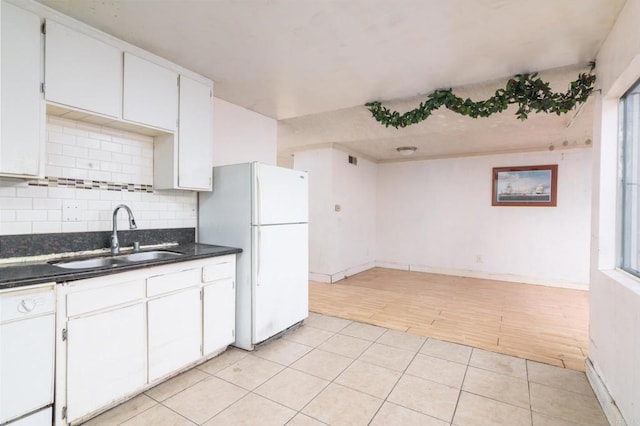 kitchen with backsplash, sink, white appliances, white cabinetry, and light tile patterned floors