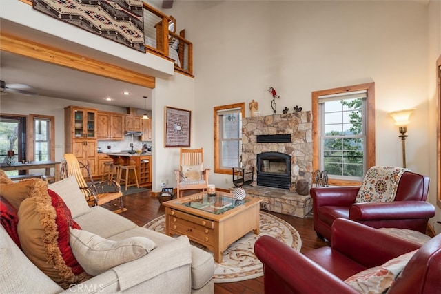 living room with ceiling fan, hardwood / wood-style flooring, and a high ceiling