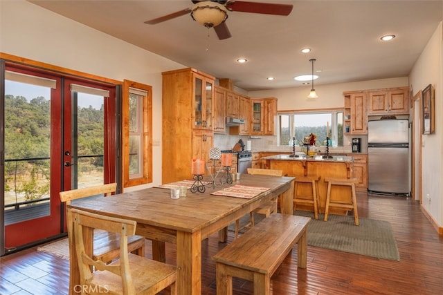 kitchen with decorative backsplash, a kitchen island, stainless steel appliances, ceiling fan, and dark hardwood / wood-style floors