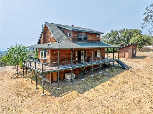 rear view of house featuring a storage shed