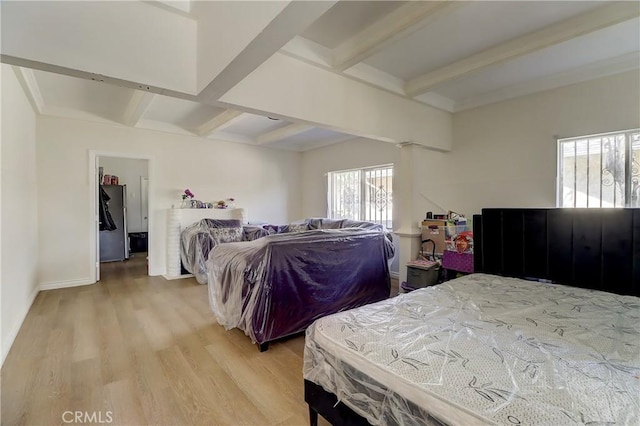 bedroom featuring beamed ceiling, stainless steel fridge, light wood-type flooring, and multiple windows