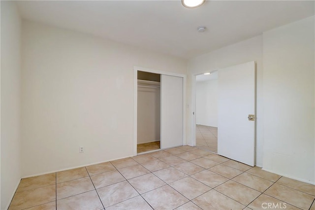 unfurnished bedroom with a closet and light tile patterned flooring