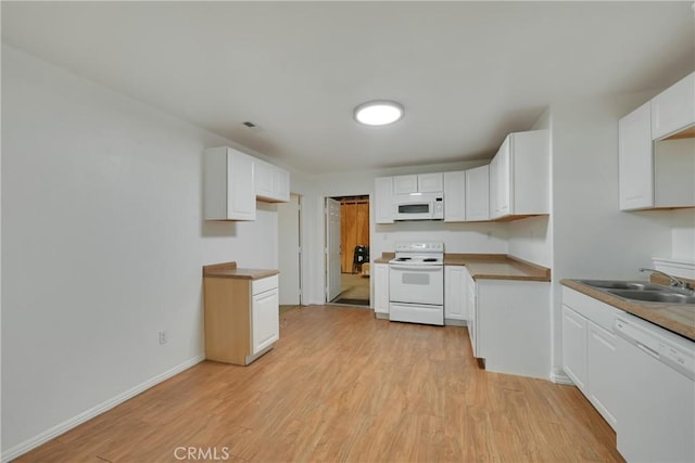 kitchen with white cabinetry, white appliances, and sink