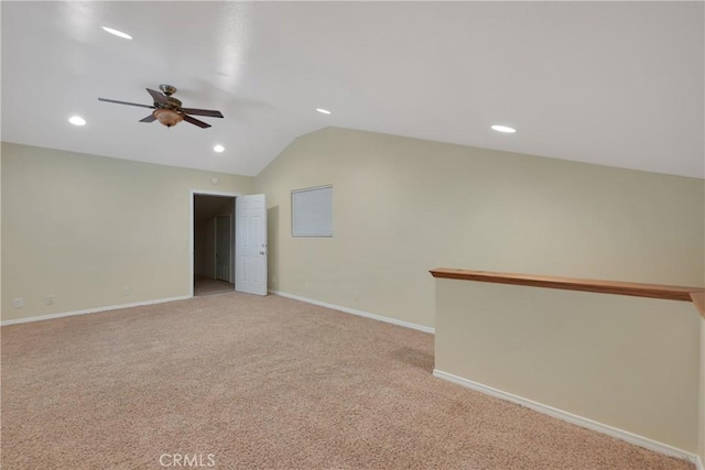 spare room with ceiling fan, light colored carpet, and vaulted ceiling