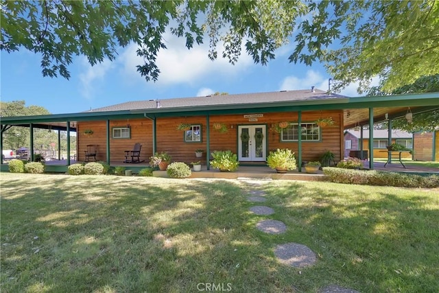 rear view of house featuring a lawn and french doors