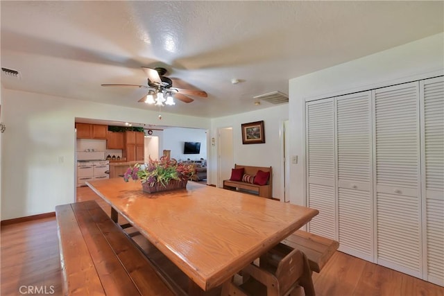 dining room with ceiling fan and light hardwood / wood-style flooring