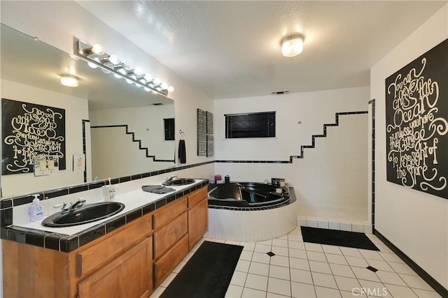 bathroom with vanity, tile patterned flooring, and tiled tub