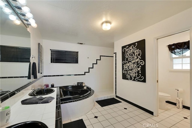 bathroom with toilet, tile patterned flooring, sink, and a washtub