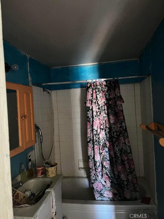 bathroom featuring shower / bath combo with shower curtain and vanity