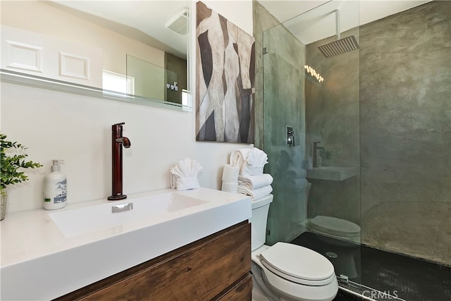 bathroom featuring a tile shower, vanity, and toilet