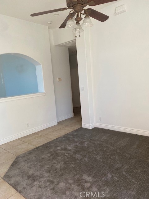 tiled spare room with ceiling fan