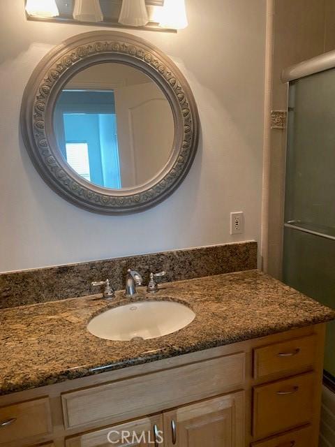 full bathroom with an enclosed shower and vanity