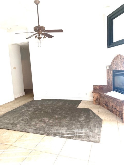 unfurnished living room with tile patterned flooring and ceiling fan