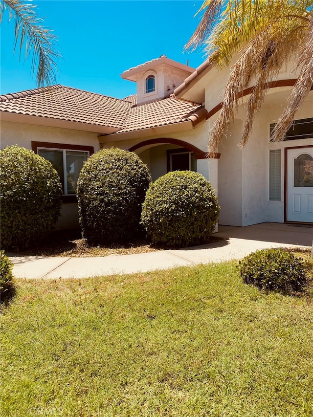 view of side of property with a lawn and a patio