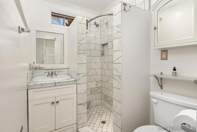 bathroom featuring a tile shower, vanity, crown molding, and toilet