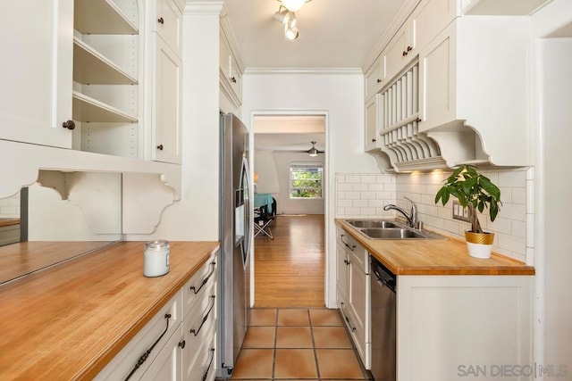 kitchen featuring dark tile patterned flooring, white cabinetry, butcher block counters, and appliances with stainless steel finishes