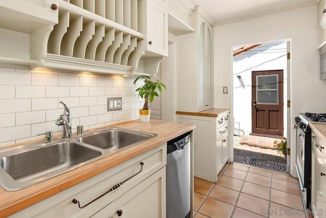 kitchen with dishwasher, butcher block countertops, sink, and white cabinetry