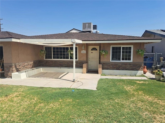 ranch-style home featuring a front yard and cooling unit