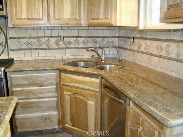 kitchen featuring dishwasher, light brown cabinets, light stone countertops, and sink