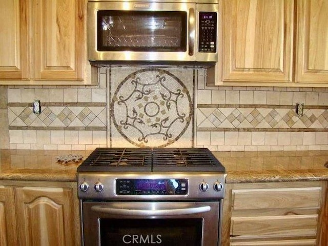 kitchen with light stone countertops, decorative backsplash, and stainless steel appliances