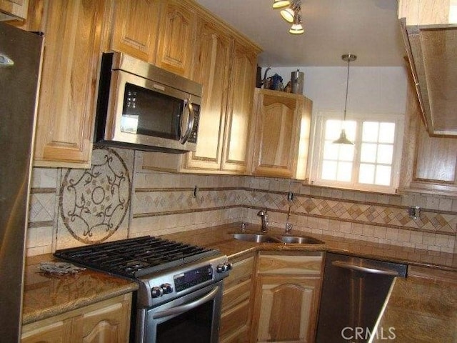 kitchen with sink, tasteful backsplash, ventilation hood, decorative light fixtures, and appliances with stainless steel finishes