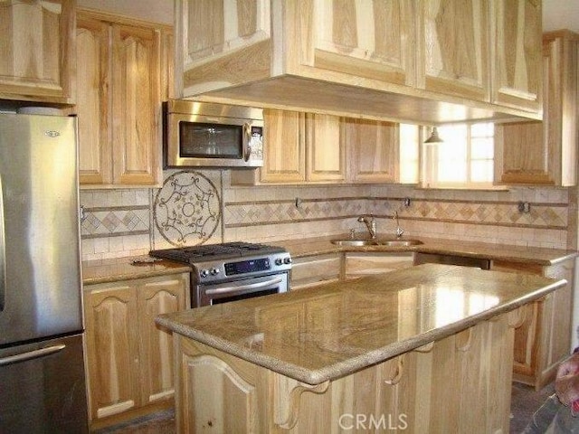 kitchen with light brown cabinets, sink, light stone countertops, and stainless steel appliances