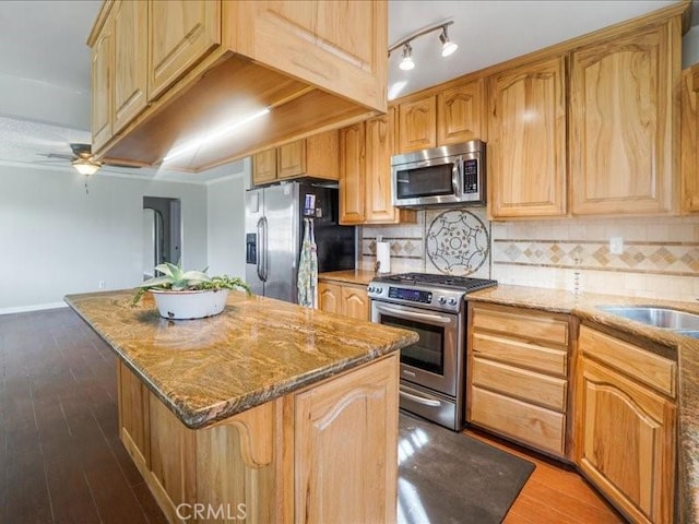 kitchen with a kitchen island, dark hardwood / wood-style flooring, appliances with stainless steel finishes, and tasteful backsplash