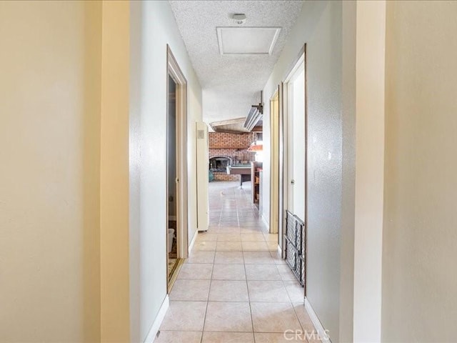 hallway featuring light tile patterned floors and a textured ceiling