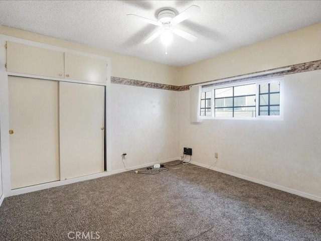 unfurnished bedroom featuring carpet, a textured ceiling, a closet, and ceiling fan