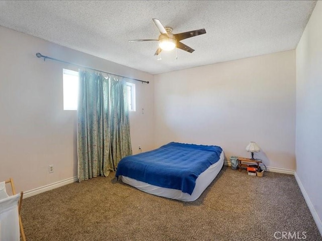 bedroom with ceiling fan, carpet, and a textured ceiling