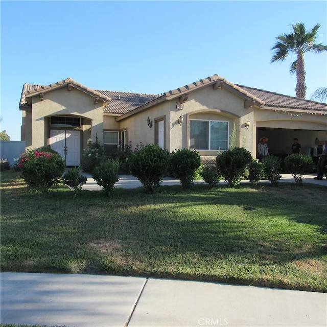 mediterranean / spanish home with a front lawn and a garage