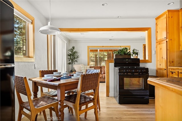 dining space featuring crown molding and light wood-type flooring