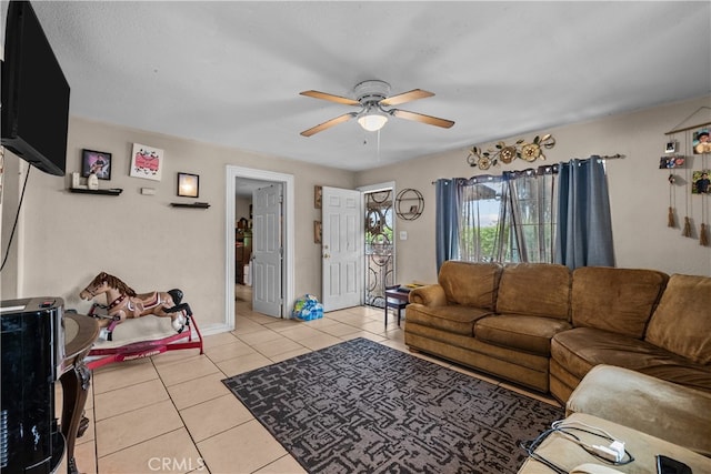 living room featuring ceiling fan, light tile patterned flooring, and a textured ceiling