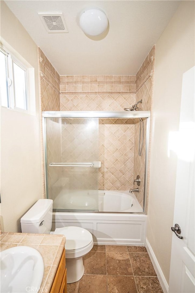 full bathroom with shower / bath combination with glass door, vanity, and toilet