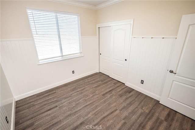 unfurnished bedroom featuring dark hardwood / wood-style flooring, a closet, and ornamental molding