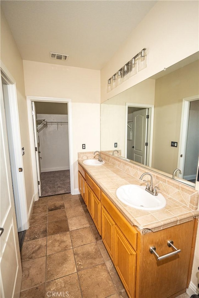 110 Montage Dr, Merced, CA 95348 - bathroom with double vanity, a spacious closet, and baseboards