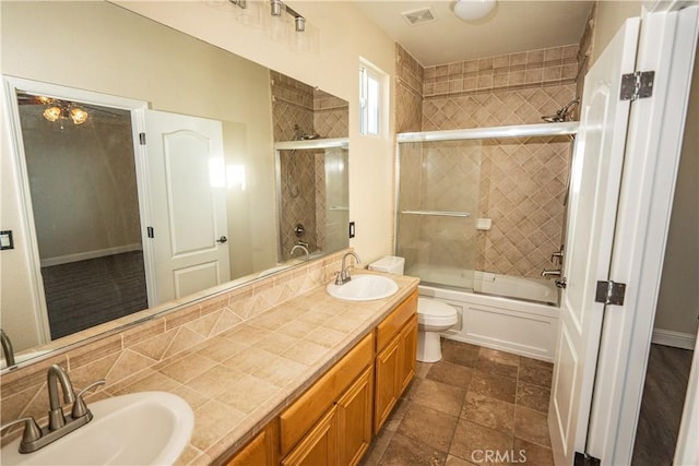 full bathroom featuring toilet, vanity, and combined bath / shower with glass door