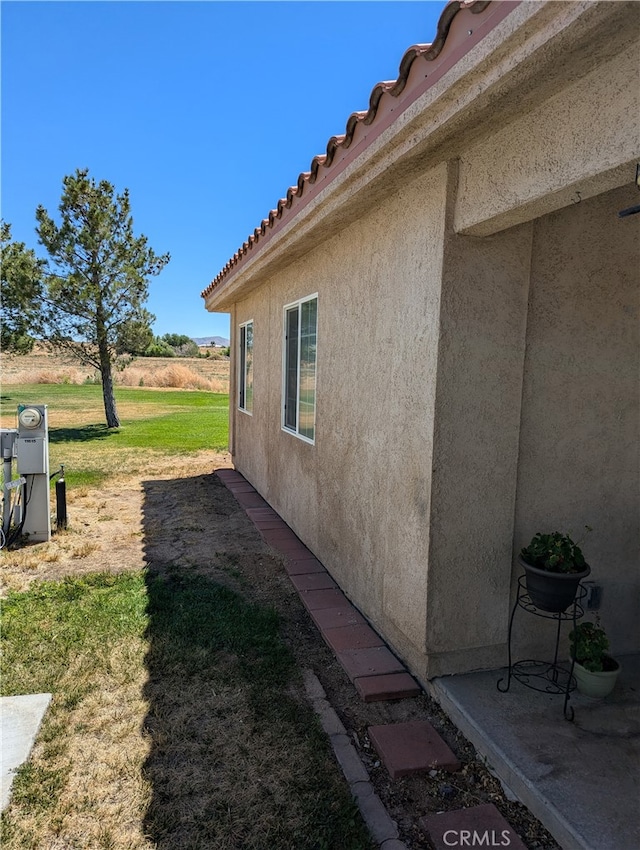 view of side of home with a yard