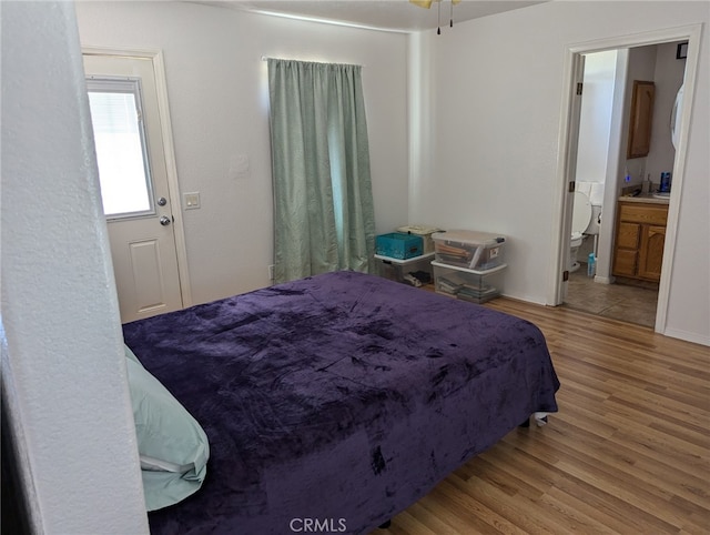 bedroom with wood-type flooring and ensuite bath