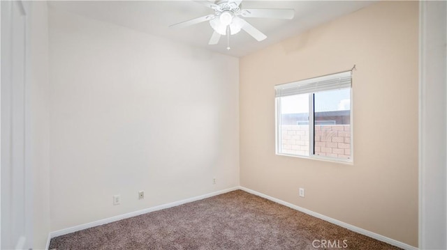 carpeted spare room with baseboards and ceiling fan