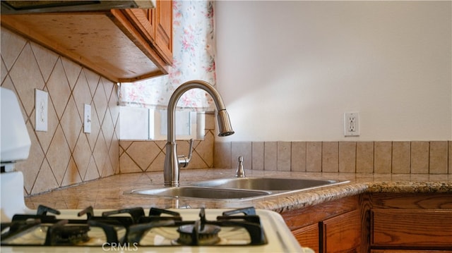 kitchen featuring tasteful backsplash, sink, and ventilation hood