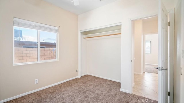 unfurnished bedroom with ceiling fan, a closet, and light colored carpet