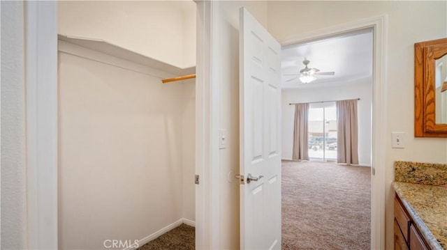 interior space featuring baseboards, vanity, and ceiling fan