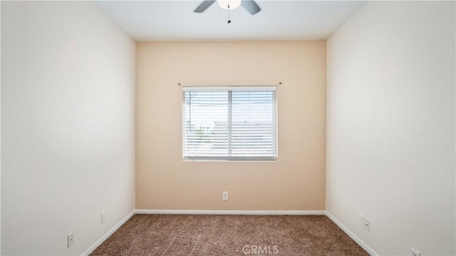 carpeted spare room with baseboards and a ceiling fan