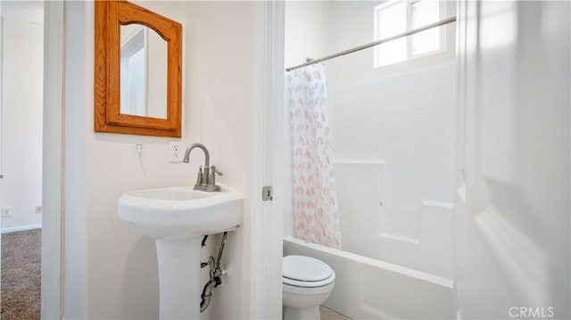 bathroom with shower / bath combination with curtain and toilet