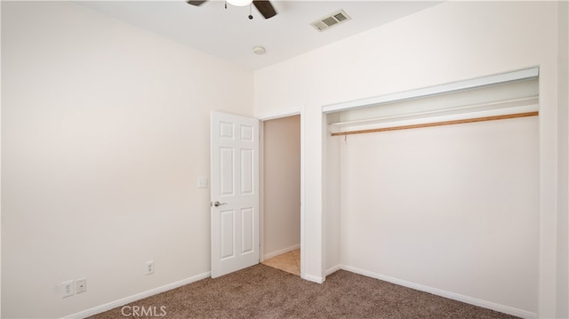 unfurnished bedroom with carpet flooring, ceiling fan, and a closet