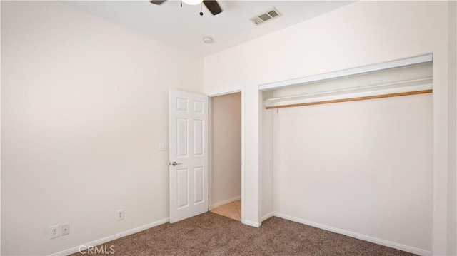 unfurnished bedroom with carpet flooring, baseboards, visible vents, a ceiling fan, and a closet