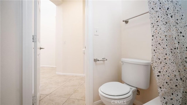 full bathroom with a shower with shower curtain, toilet, and tile patterned floors