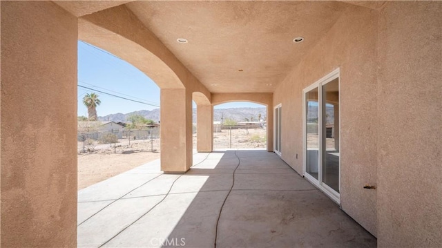 view of patio / terrace with fence and a mountain view
