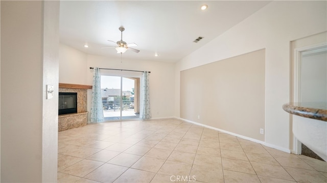 unfurnished living room with a premium fireplace, light tile patterned floors, lofted ceiling, and ceiling fan